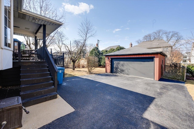 view of side of home with an outbuilding, stairway, a shingled roof, and a garage