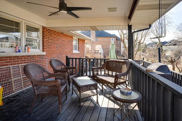 wooden deck with an outdoor living space and a ceiling fan