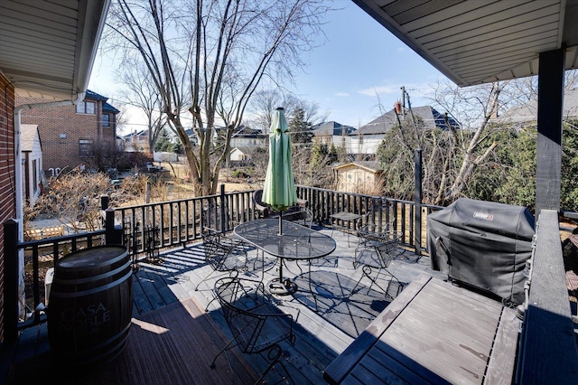 deck with outdoor dining area and a grill