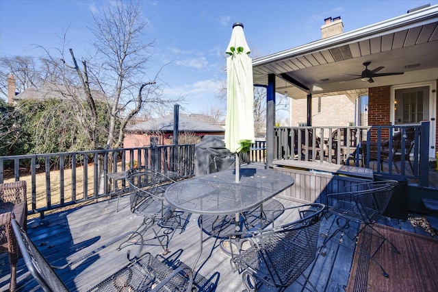 wooden deck with outdoor dining space and a ceiling fan