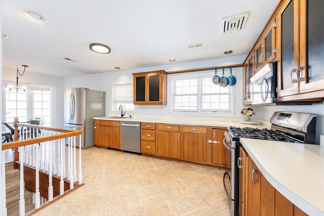 kitchen featuring a sink, visible vents, appliances with stainless steel finishes, and brown cabinetry