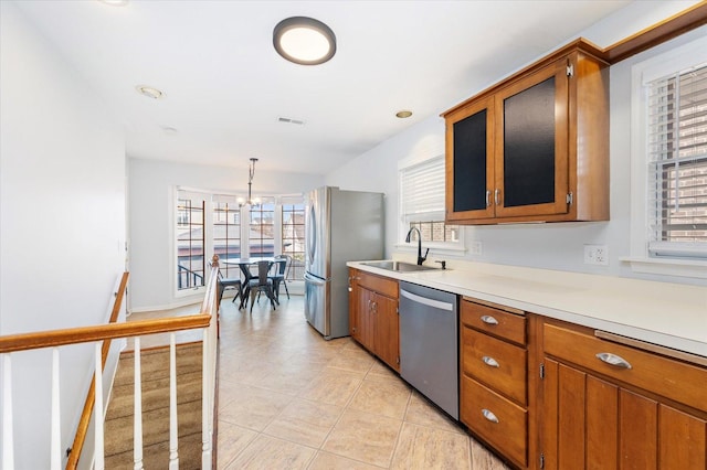 kitchen featuring visible vents, a sink, light countertops, appliances with stainless steel finishes, and brown cabinets