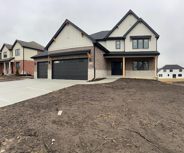 modern farmhouse featuring brick siding, board and batten siding, concrete driveway, and an attached garage