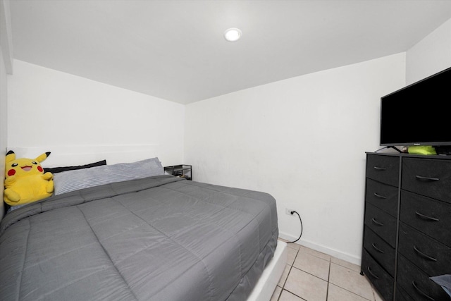 bedroom with light tile patterned flooring and baseboards