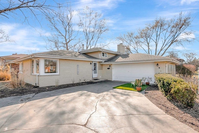 view of front of property featuring an attached garage, brick siding, driveway, and a chimney