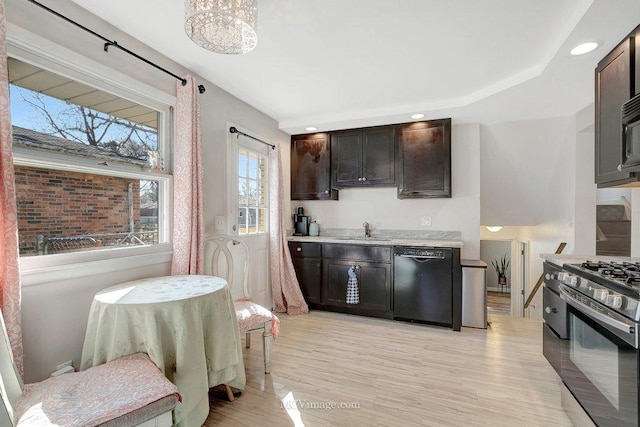 kitchen with a sink, gas range oven, light wood finished floors, dishwasher, and light countertops