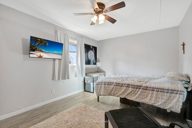 bedroom featuring wood finished floors, baseboards, and ceiling fan