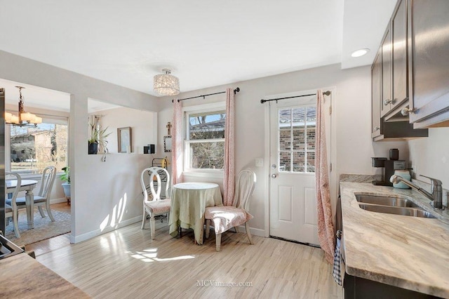 dining room featuring a notable chandelier, light wood-style flooring, and baseboards