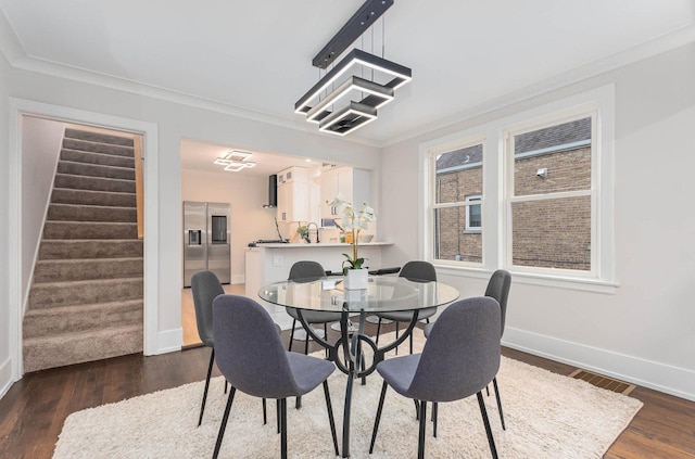 dining space featuring stairway, wood finished floors, visible vents, baseboards, and ornamental molding