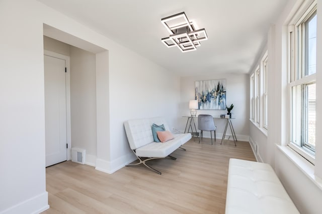 sitting room featuring visible vents, baseboards, and wood finished floors