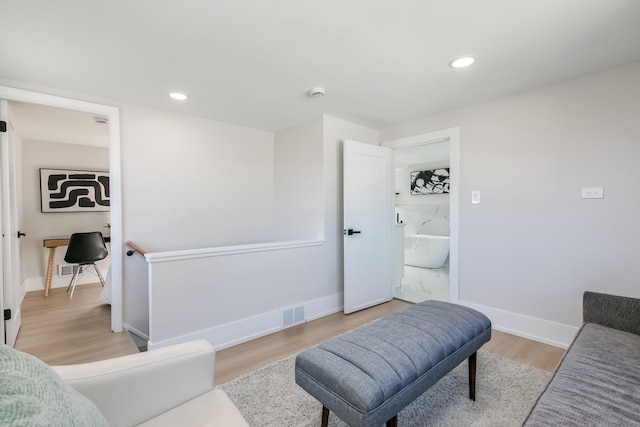 living room featuring light wood-style flooring, recessed lighting, and baseboards