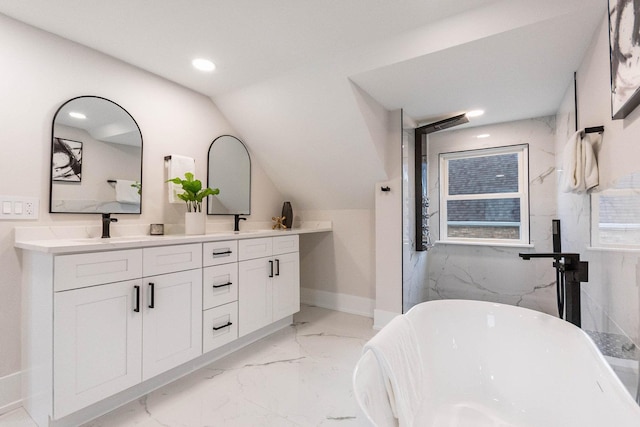 bathroom featuring a sink, lofted ceiling, a soaking tub, and marble finish floor