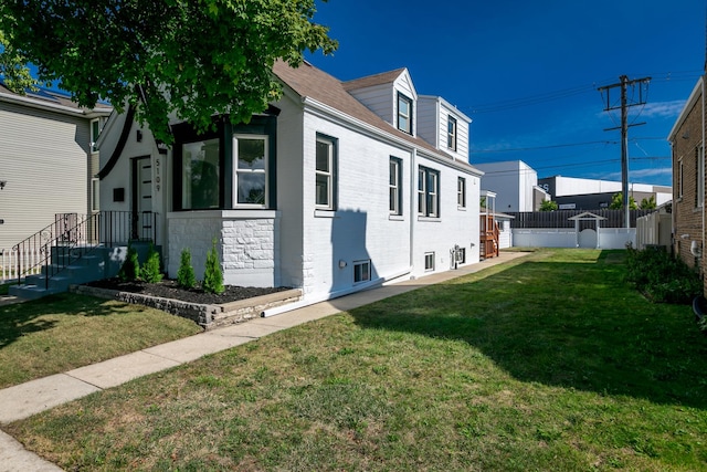 view of side of property with a lawn and fence