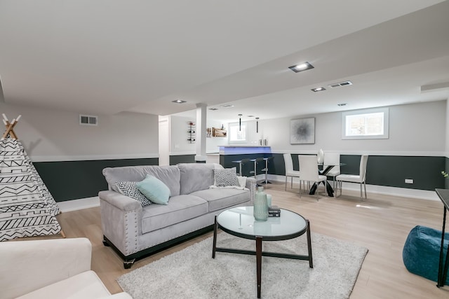 living area featuring light wood finished floors, visible vents, and baseboards