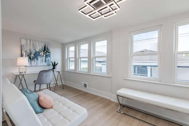 sitting room with visible vents, baseboards, and wood finished floors