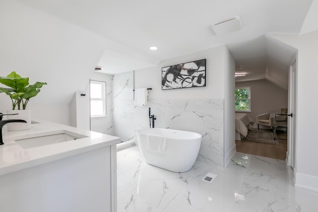 bathroom with a freestanding tub, marble finish floor, ensuite bathroom, a sink, and double vanity