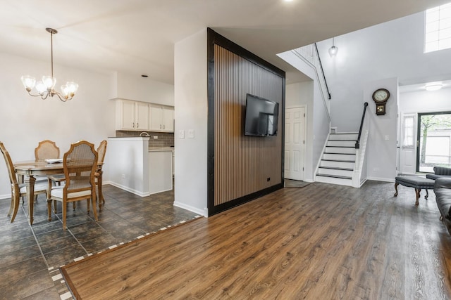 interior space with an inviting chandelier, baseboards, dark wood finished floors, and stairway
