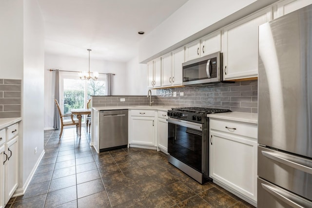 kitchen featuring light countertops, a chandelier, appliances with stainless steel finishes, and tasteful backsplash