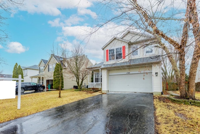 traditional-style house with aphalt driveway, an attached garage, fence, and a front yard