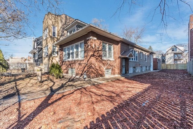 exterior space with brick siding and fence