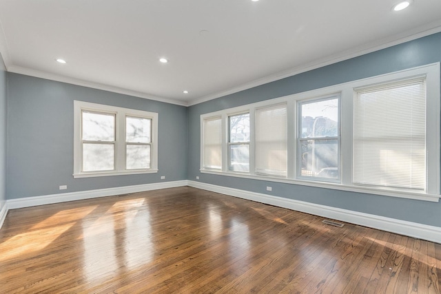 unfurnished room with visible vents, plenty of natural light, baseboards, and ornamental molding