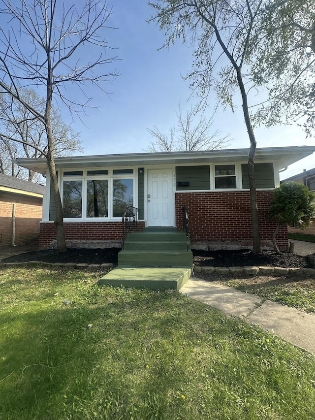 ranch-style house with a front yard and brick siding