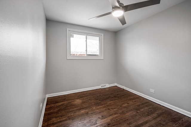 unfurnished room with a ceiling fan, dark wood-style floors, visible vents, and baseboards