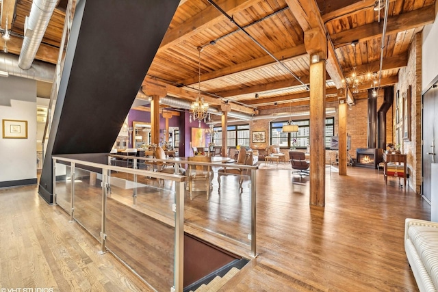 interior space featuring wood finished floors, beamed ceiling, a notable chandelier, and wood ceiling