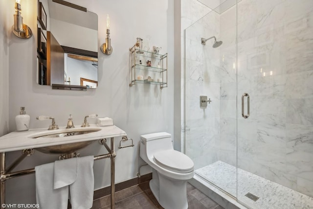 full bathroom featuring baseboards, toilet, a stall shower, tile patterned floors, and a sink