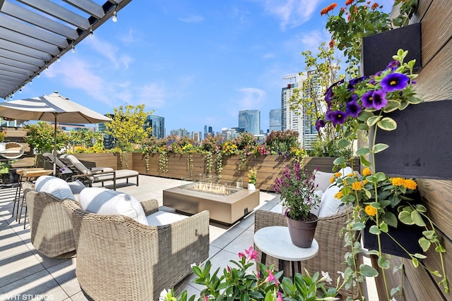 view of patio featuring an outdoor living space with a fire pit, a view of city, and a pergola
