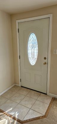 entrance foyer with light tile patterned floors and baseboards