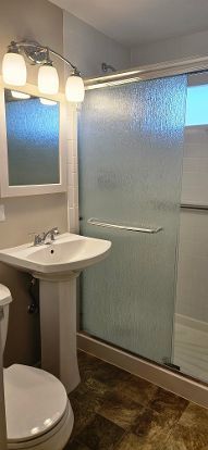 bathroom with a shower stall and toilet