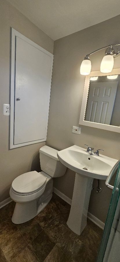 bathroom with toilet and baseboards