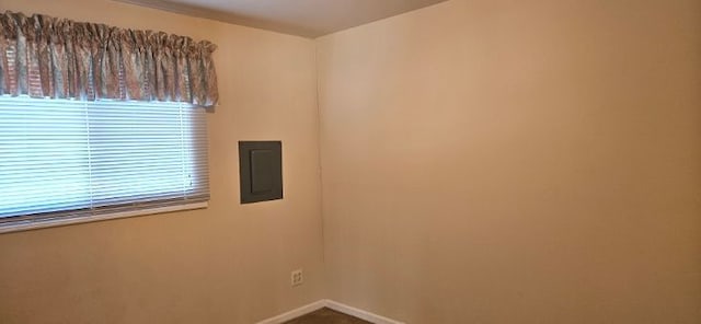 spare room with electric panel and baseboards