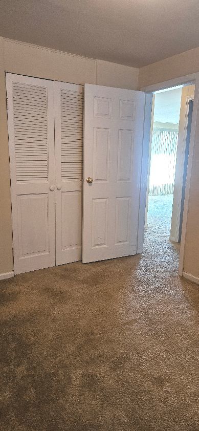 unfurnished bedroom featuring a closet and carpet floors