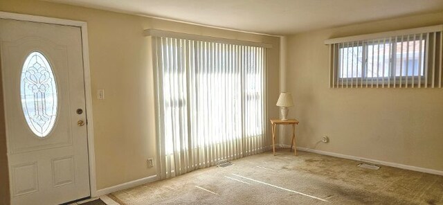 carpeted entrance foyer with baseboards