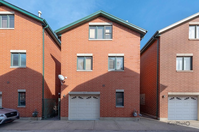 rear view of property with brick siding and a garage