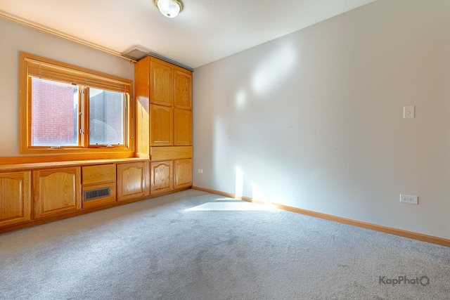 spare room with baseboards, visible vents, and light carpet