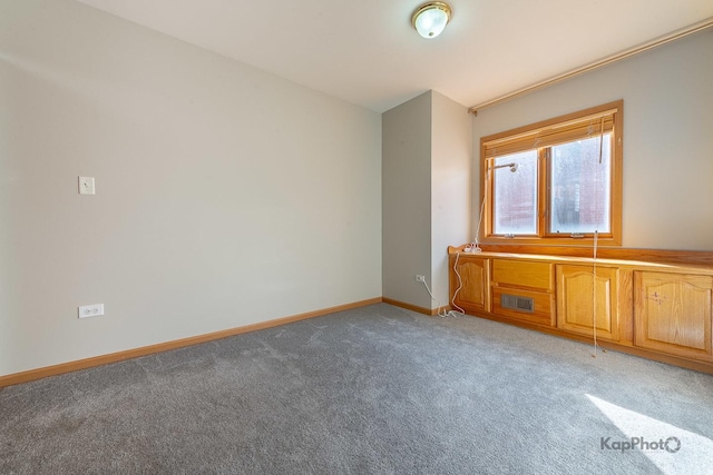 empty room featuring visible vents, baseboards, and light colored carpet