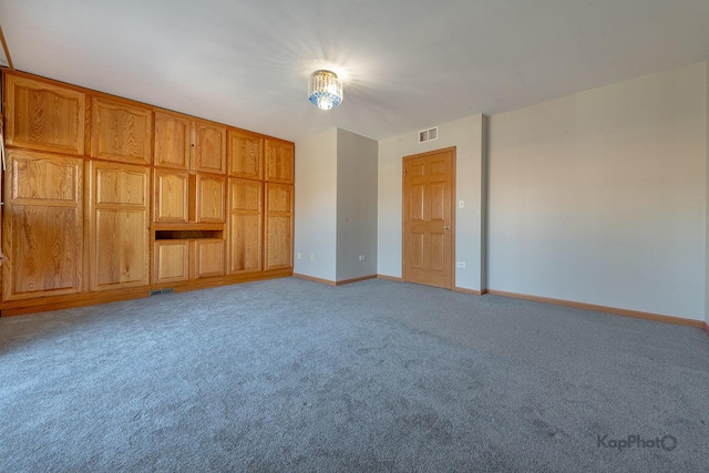 empty room with visible vents, baseboards, and light carpet