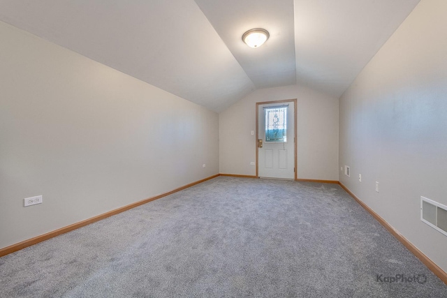 bonus room featuring visible vents, light colored carpet, baseboards, and vaulted ceiling