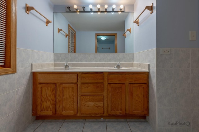 full bathroom featuring tile patterned floors, tile walls, double vanity, and a sink