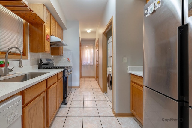 kitchen with a sink, under cabinet range hood, backsplash, stainless steel appliances, and light tile patterned floors