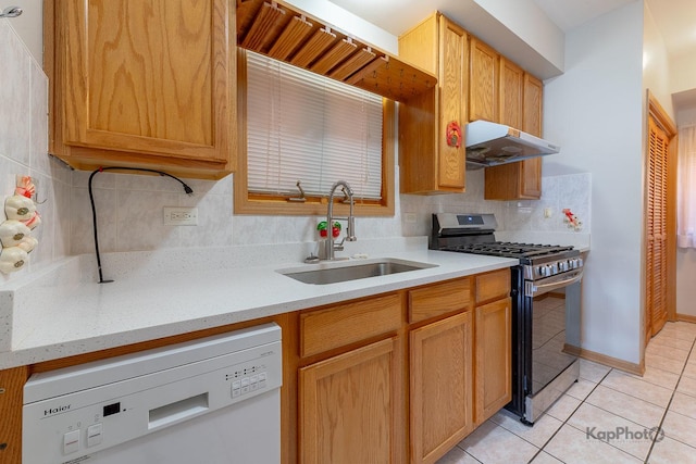 kitchen with stainless steel gas stove, a sink, under cabinet range hood, light tile patterned floors, and dishwasher