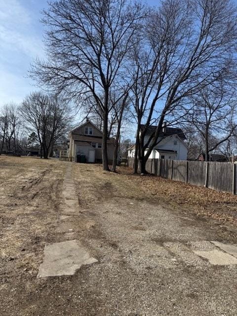 view of yard with driveway and fence