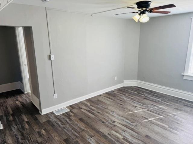 spare room featuring dark wood-style floors and baseboards