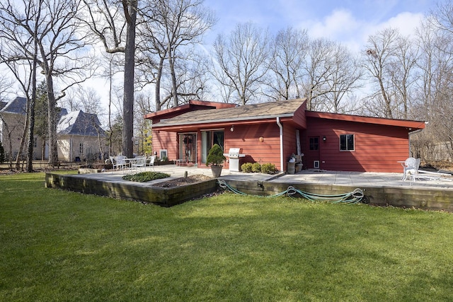 back of property with a patio area and a yard