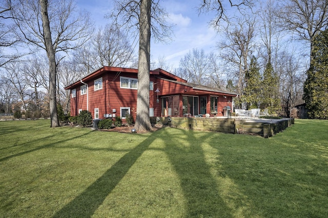 rear view of property featuring cooling unit, a patio, and a lawn