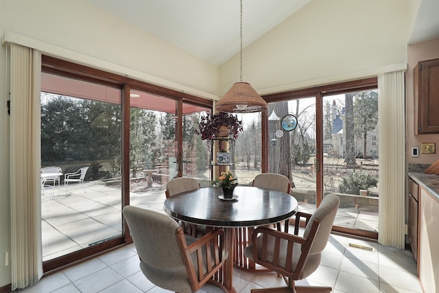 dining room with light tile patterned floors, visible vents, and high vaulted ceiling