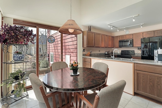 dining space featuring track lighting and light tile patterned floors